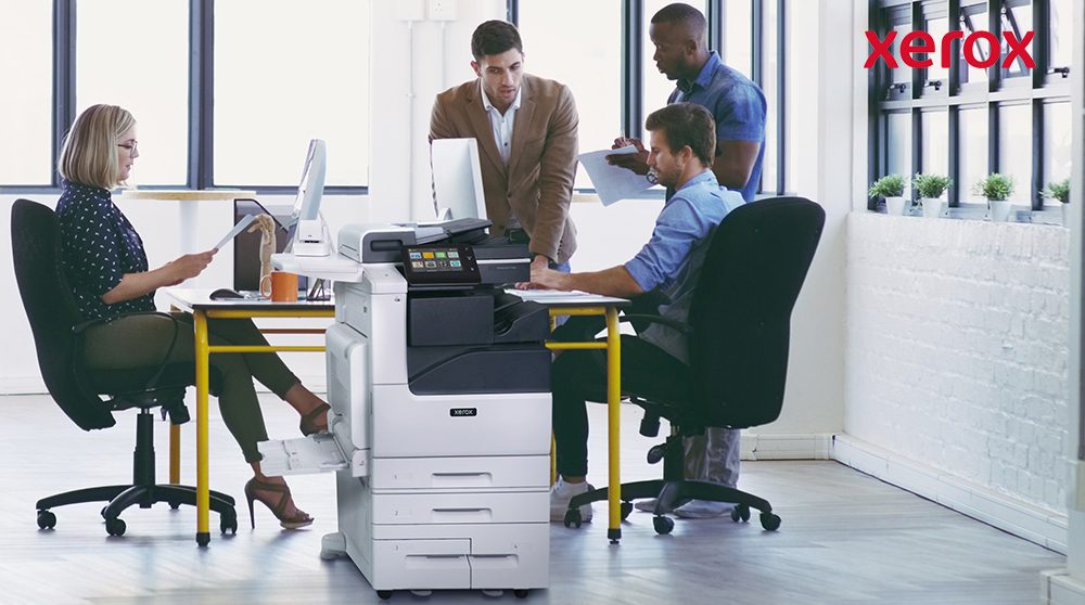 Impiegati che collaborano vicino a una stampante Xerox. Impiegati che collaborano vicino a una stampante Xerox.