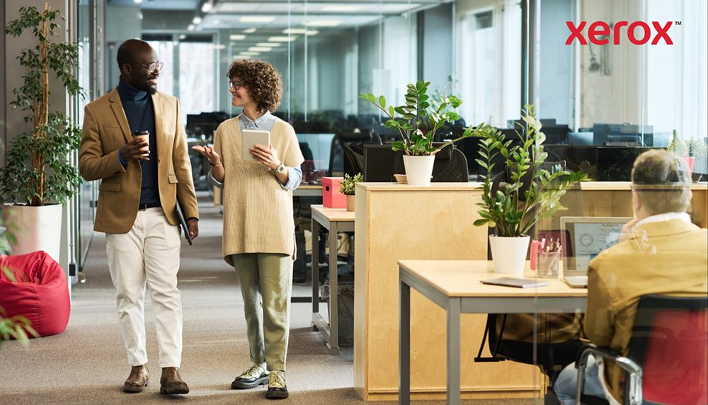 Due professionisti camminano e parlano in un ufficio moderno Due professionisti camminano e parlano in un ufficio moderno