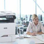 Stampante multifunzione a colori Xerox® VersaLink® C625 sul posto di lavoro Due donne al lavoro in un ufficio accanto a una stampante multifunzione a colori Xerox® VersaLink® C625